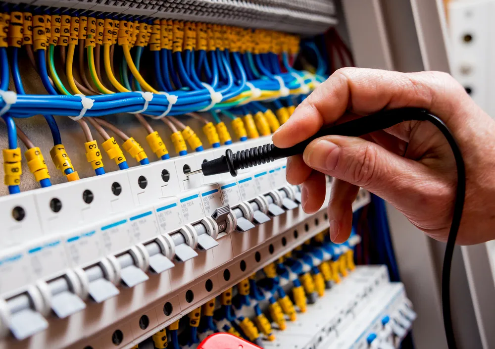 Electrician testing a switchboard while fault finding